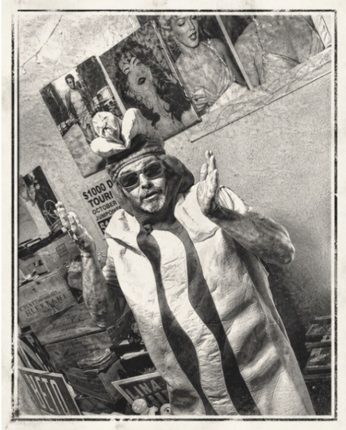 A man in a hot dog costume surrounded by old photographs